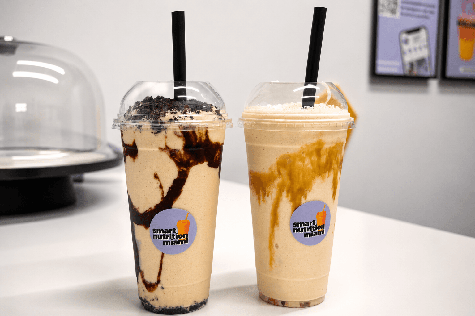 Two Smart Nutrition Miami smoothies with chocolate and caramel swirls, topped with cookie crumbles.